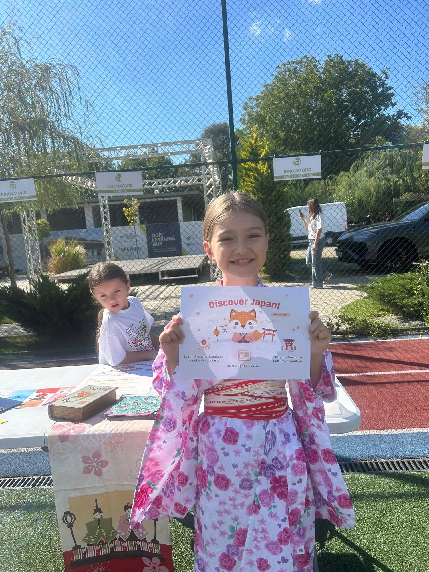 Elevi SORA la un eveniment — fetiță în yukata cu pliantul Discover Japan
